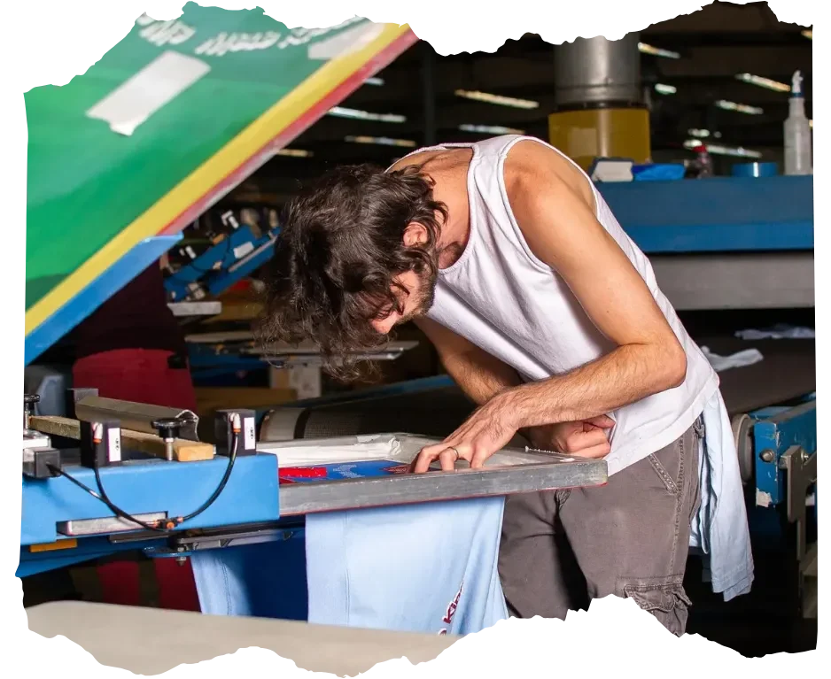 A focused craftsman screen printing a design by hand