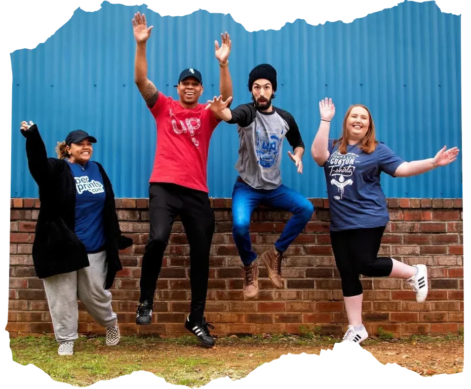 A diverse team joyfully wearing graphic tees, reflecting unity, energy, and the spirit behind